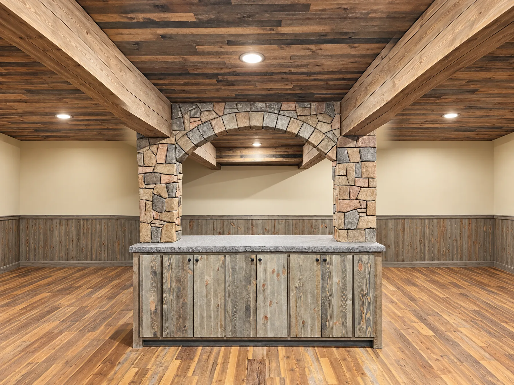 Finished basement bar with a stone arch, reclaimed wood ceiling and barnwood cabinets