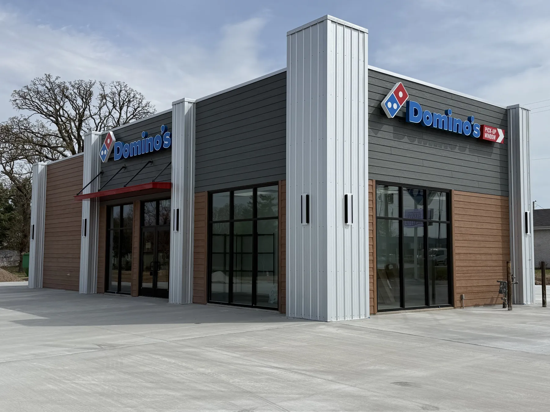Newly completed Domino's Pizza restaurant with gray and wood-look siding and metal-clad columns, built by Bates Building