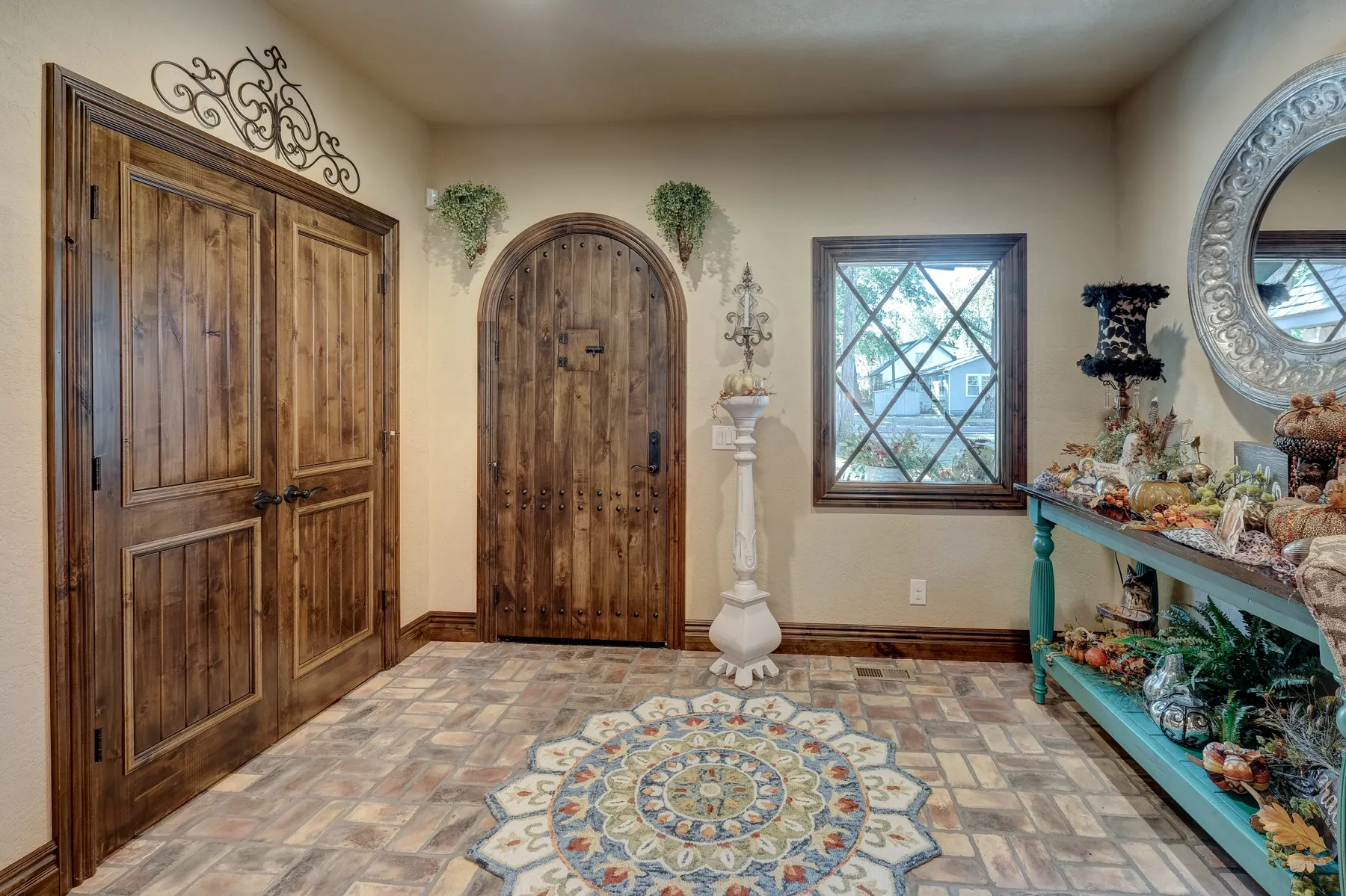 Custom arched wood doors and mosaic tile entry
