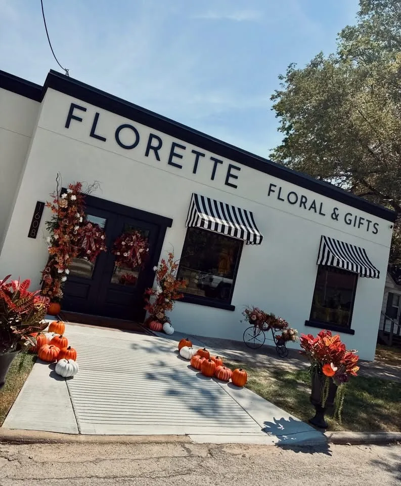 Finished Florette Floral and Gifts storefront with black lettering, striped awnings, double entry doors and a new ramp