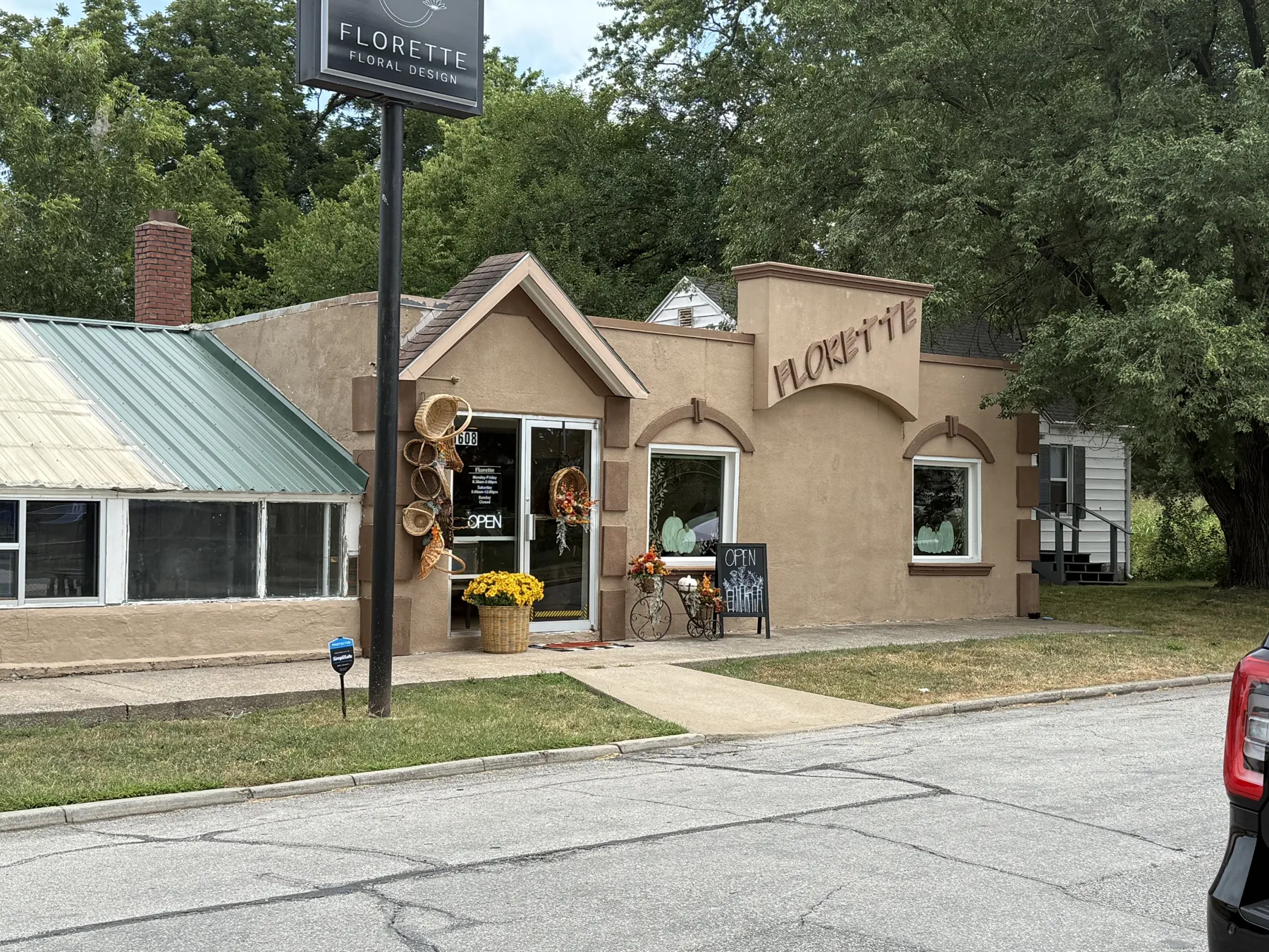 Florette's original tan stucco storefront with a green metal roof section and arched trim, before the remodel