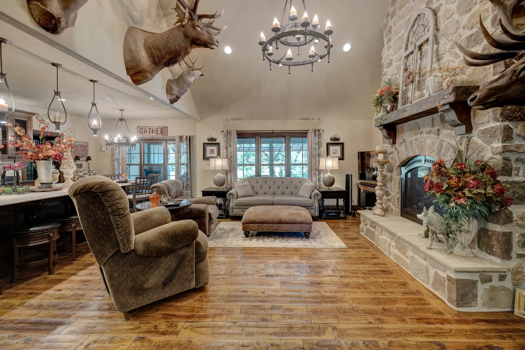 Great room with a stone fireplace and chandelier