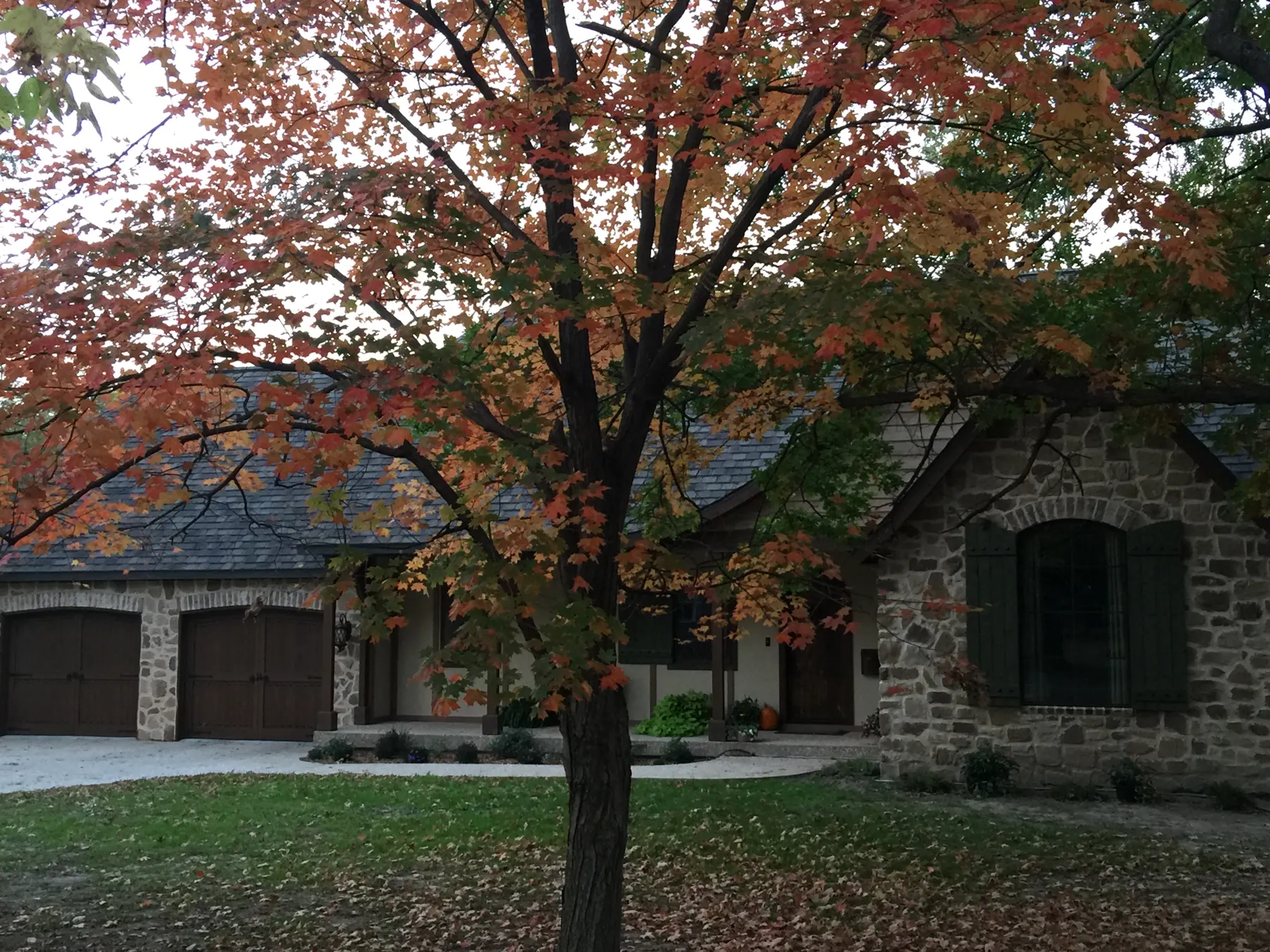 Stone and siding custom home in autumn
