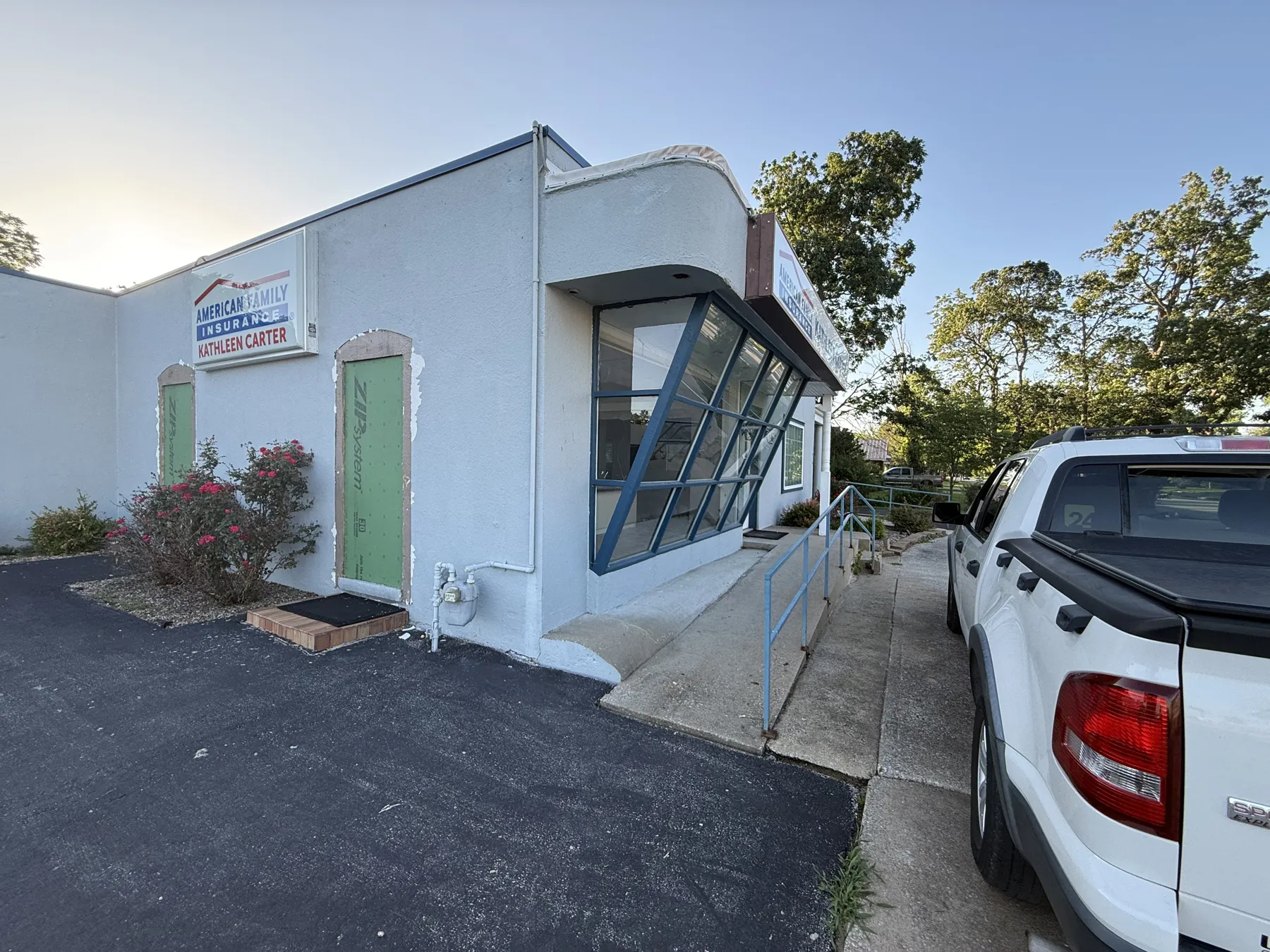 Side view of the original storefront with green doors and a rounded canopy