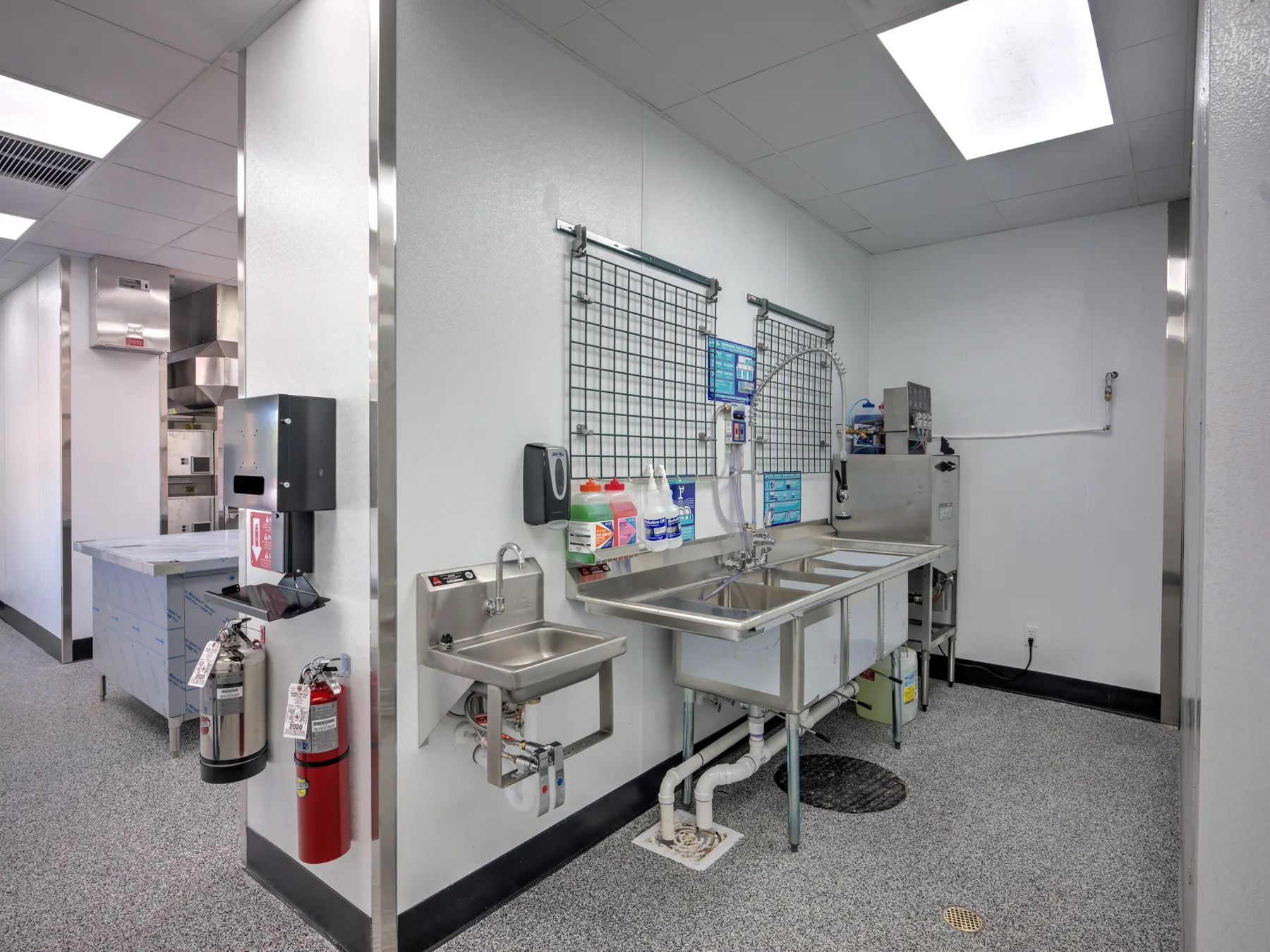 Back-of-house with stainless sinks, hand-wash station and tile floor