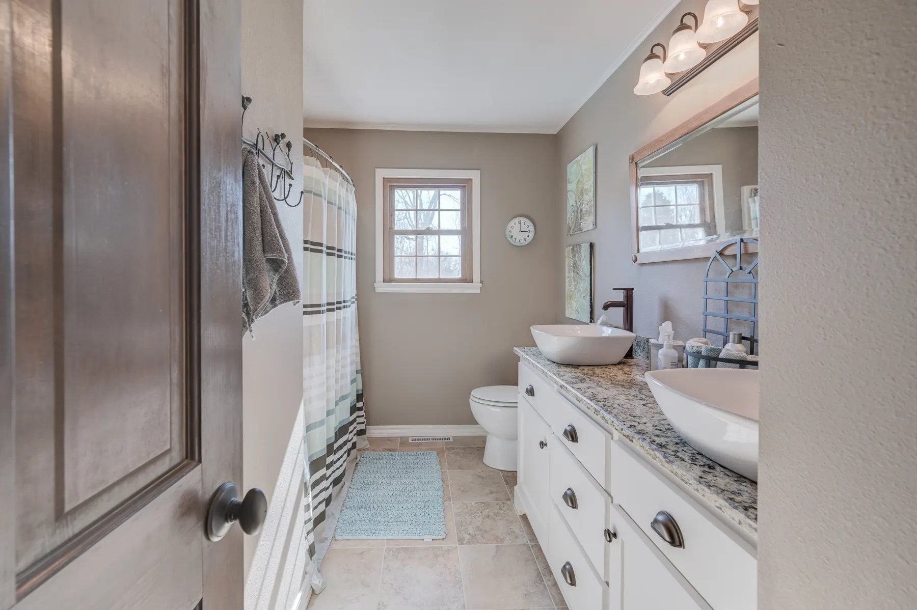 Bathroom with a white vessel sink on a granite vanity