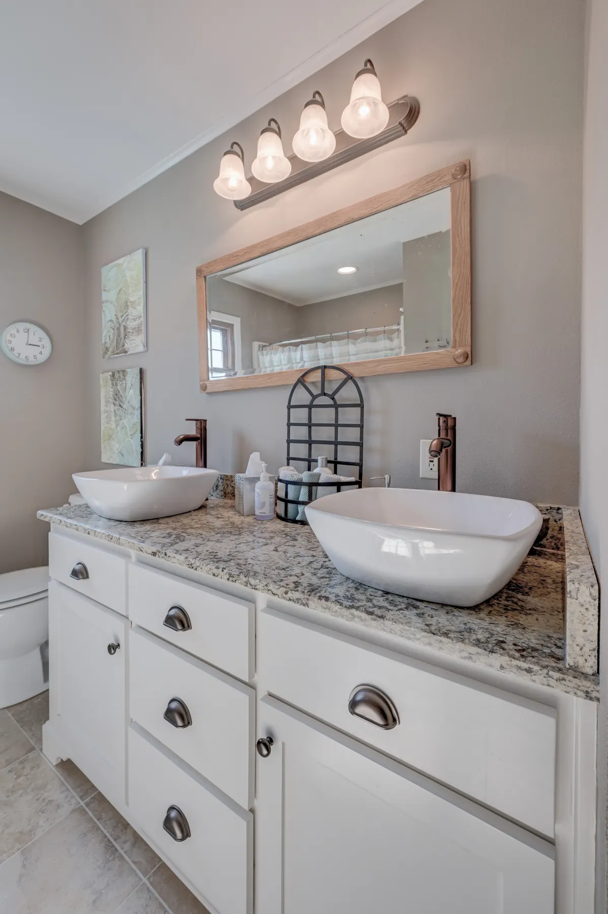 White vanity with a vessel sink and framed mirror