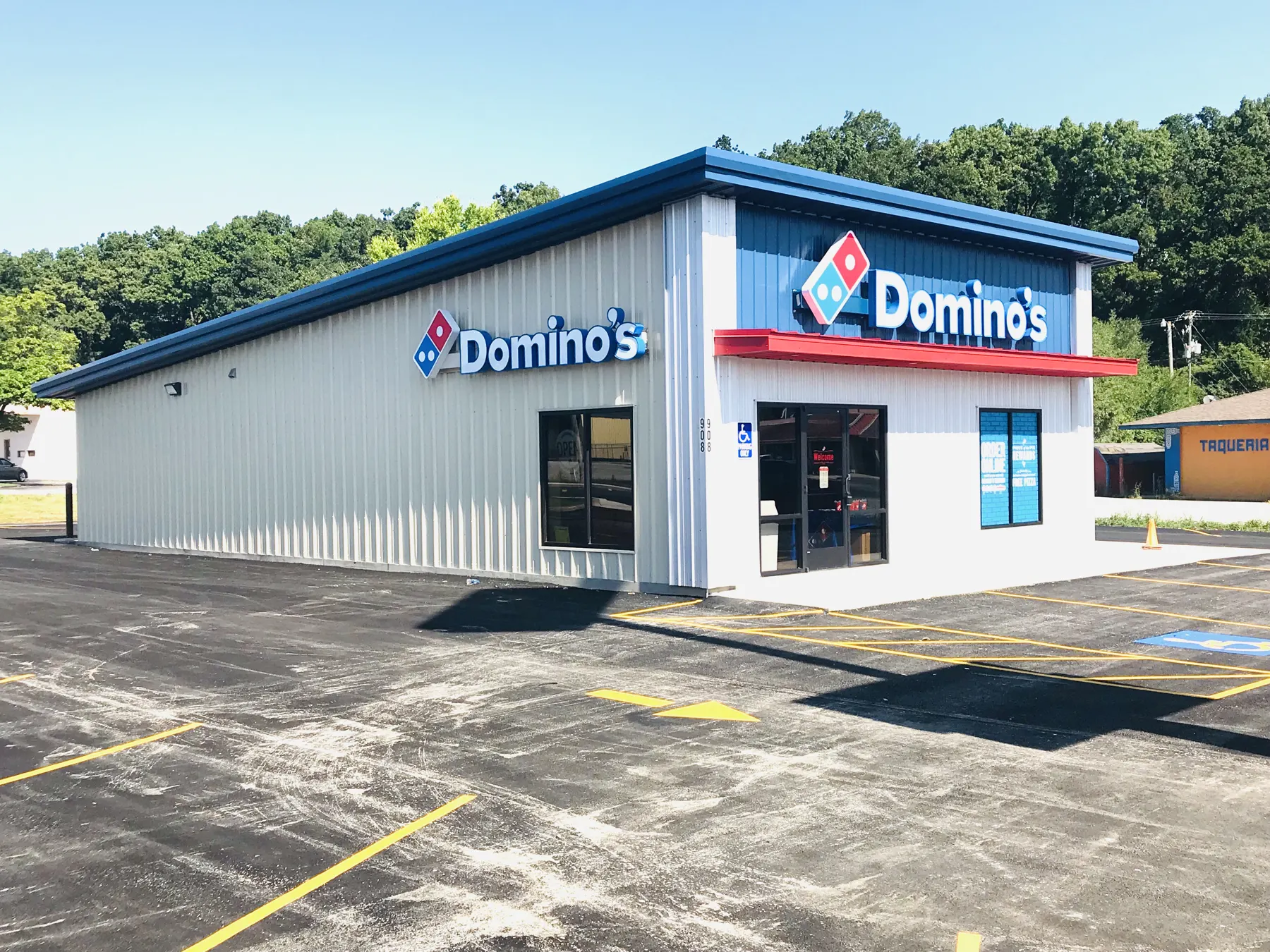 Domino's Pizza store exterior with white metal siding and blue trim