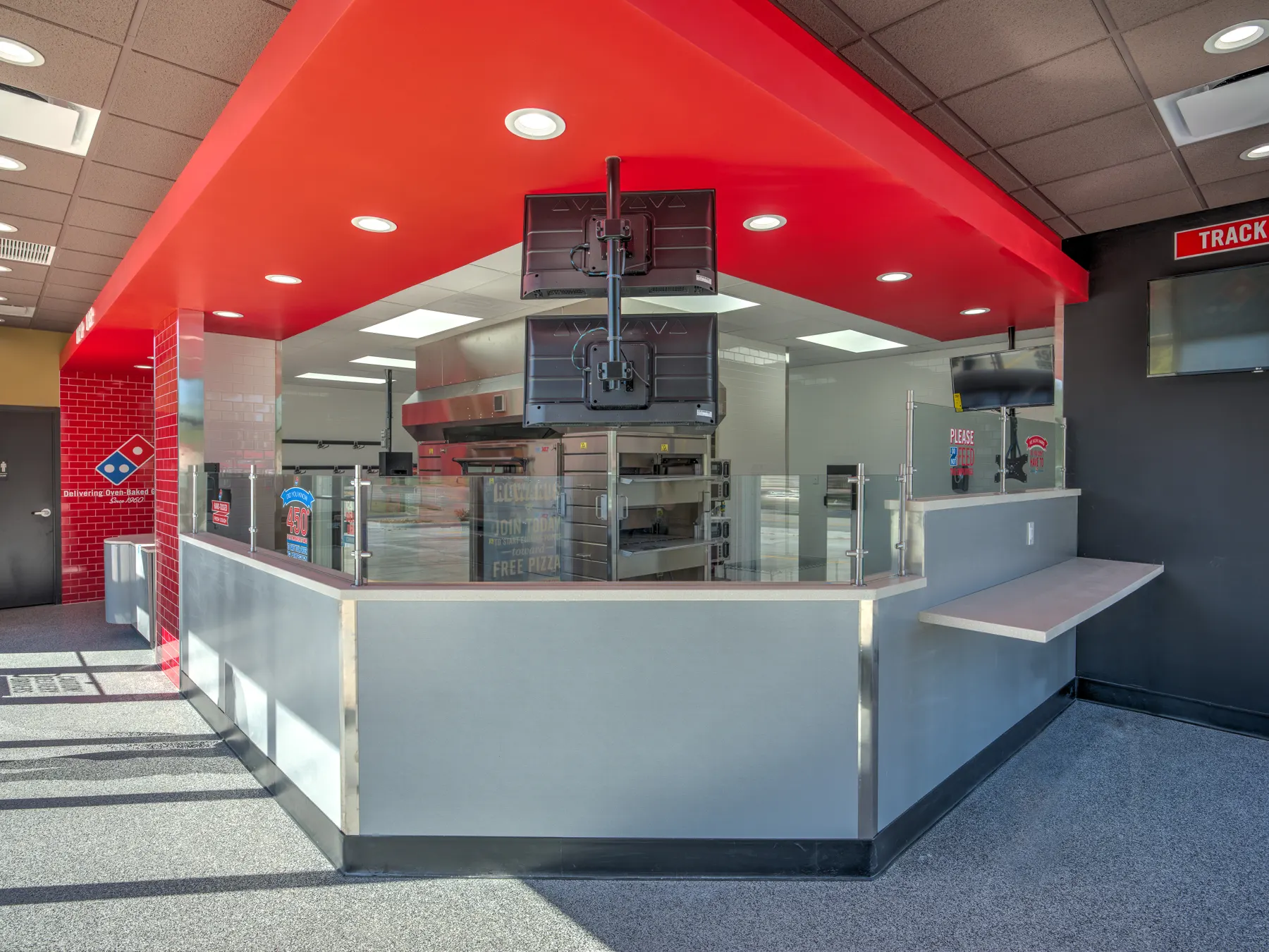Domino's interior with a red ceiling canopy and stainless pickup counter