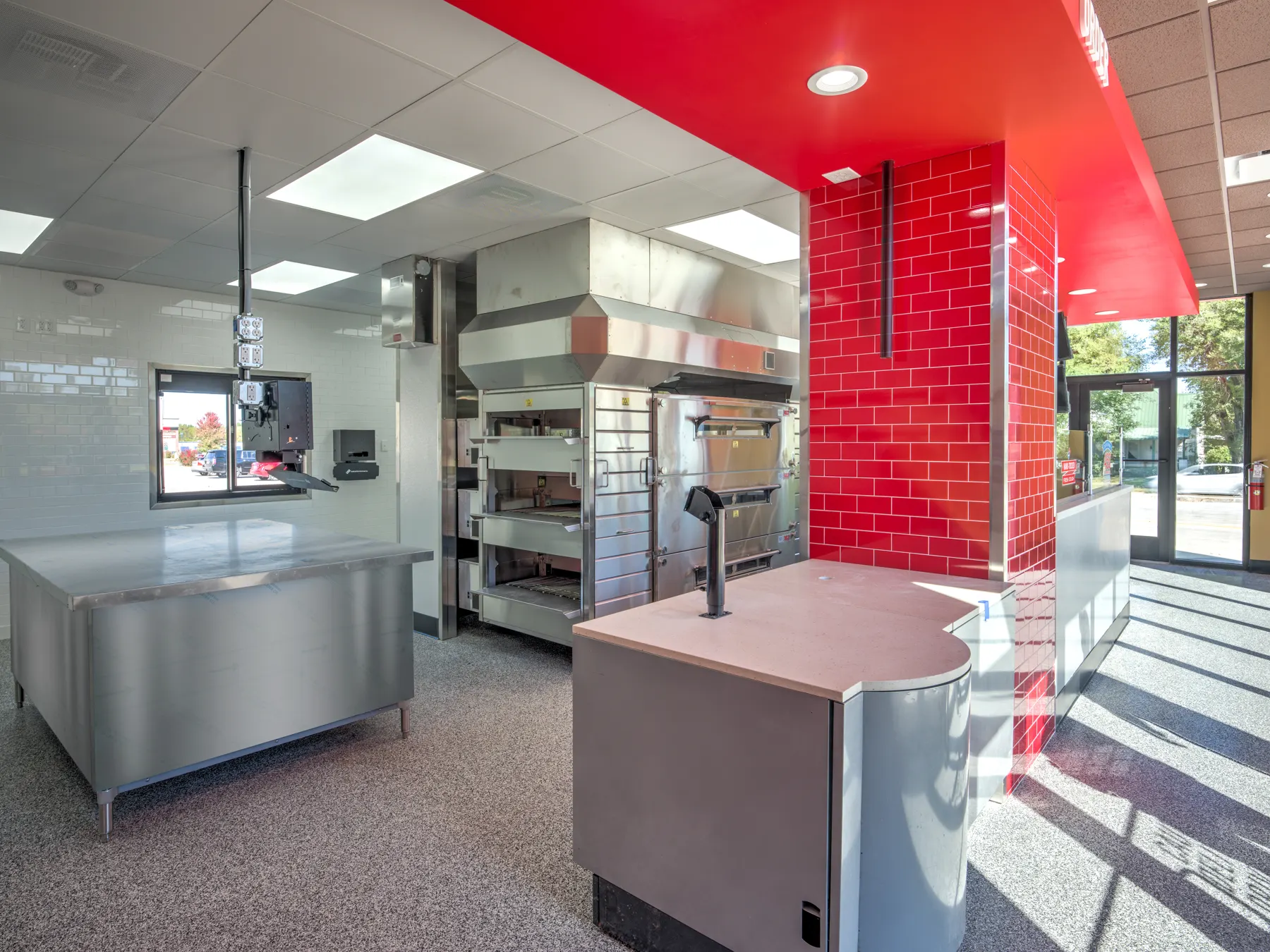 Commercial pizza kitchen with stainless prep station and red tile wall