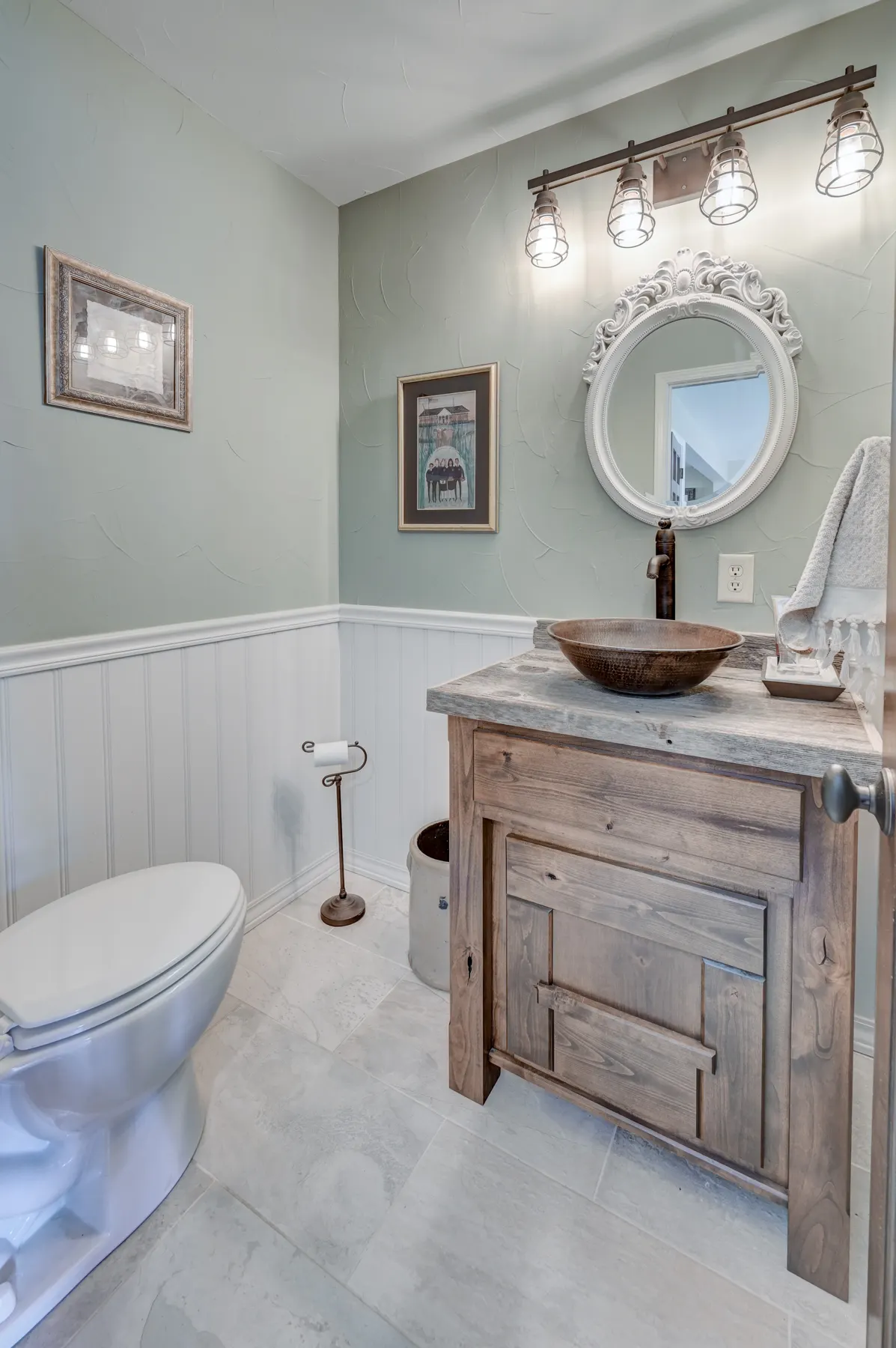Farmhouse half bath with a vessel sink and wainscoting