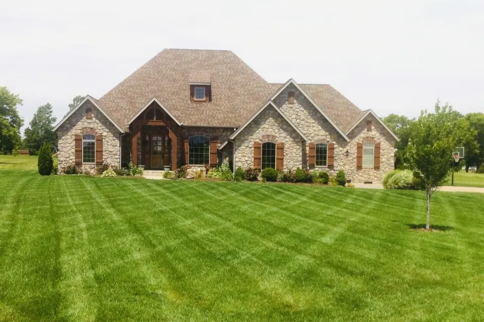 Brick home with multiple gables on a wide striped lawn
