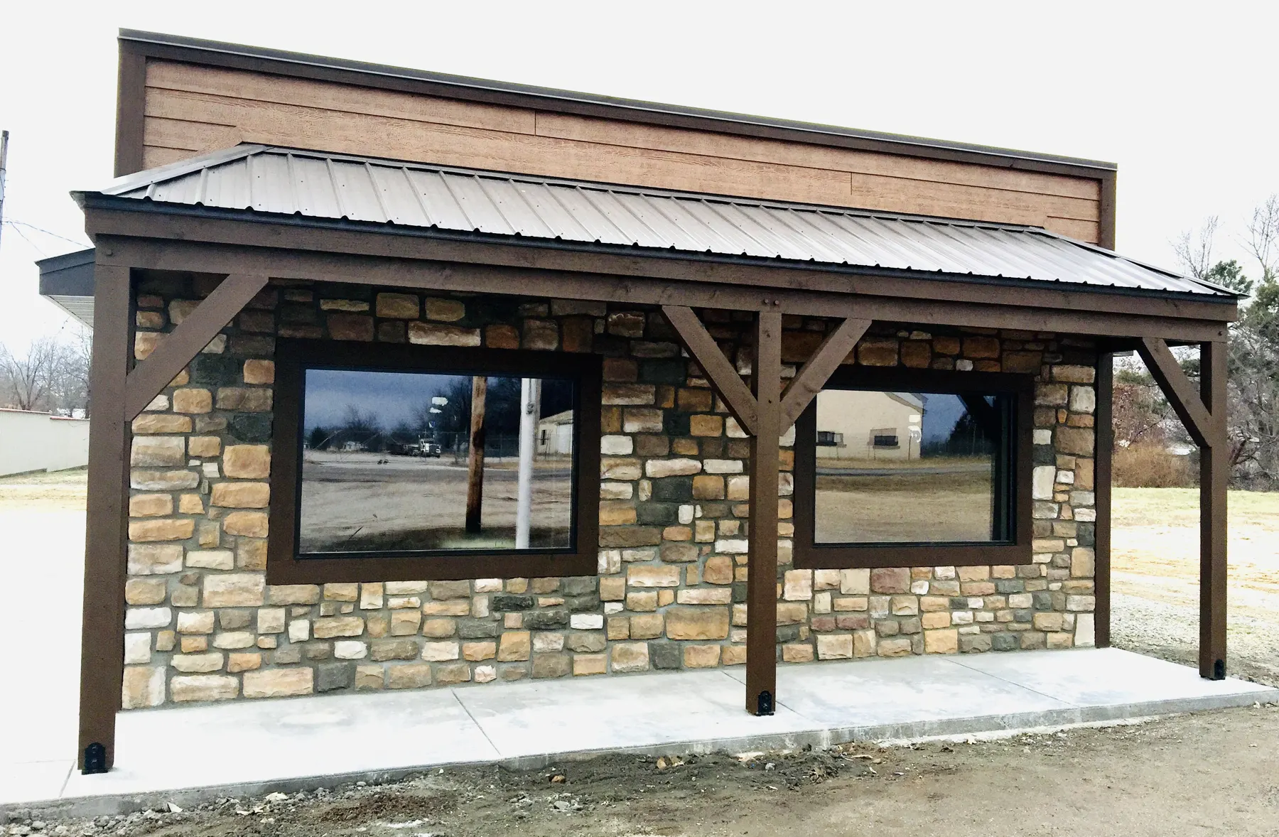 Stone and timber kiosk building with a metal roof