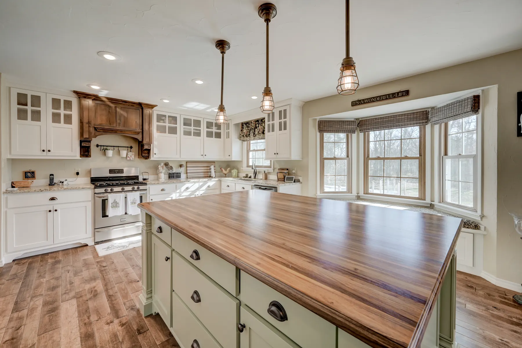 Kitchen island with a butcher-block top and green cabinet base