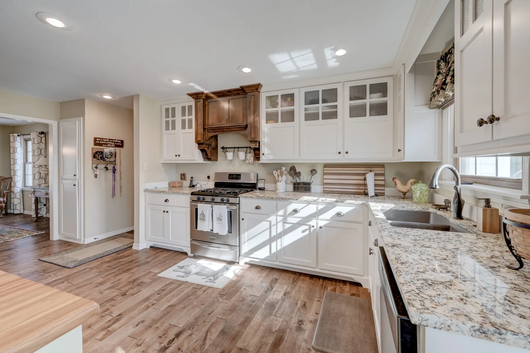 White kitchen with granite counters and a stainless range