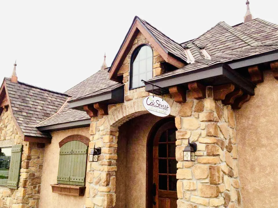 Stone European-style home with an arched entry and copper accents