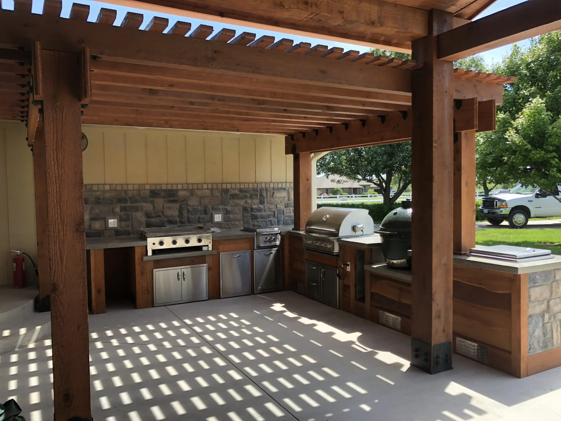 Covered outdoor kitchen under a timber pergola